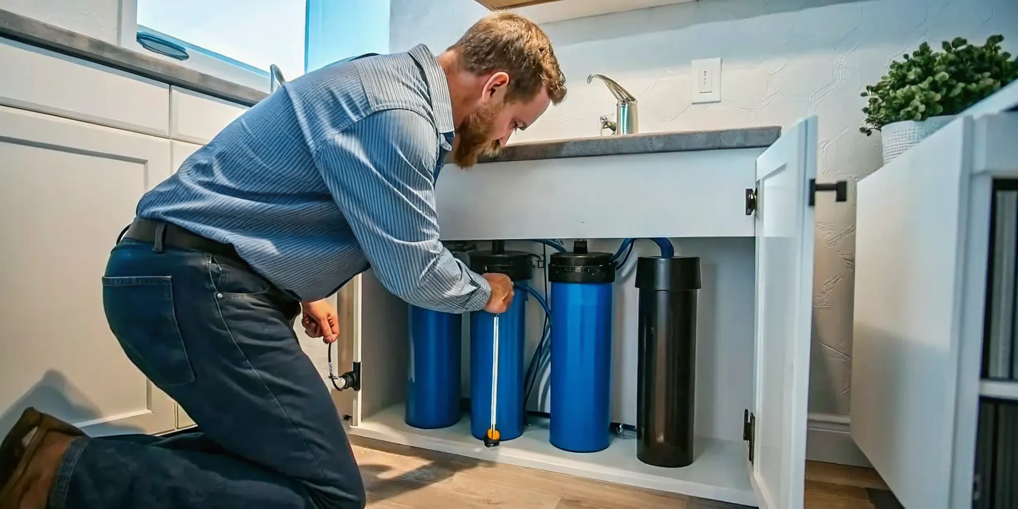 Whole-house water filtration system installation in a Florida home utility room with filter canisters and plumbing connections